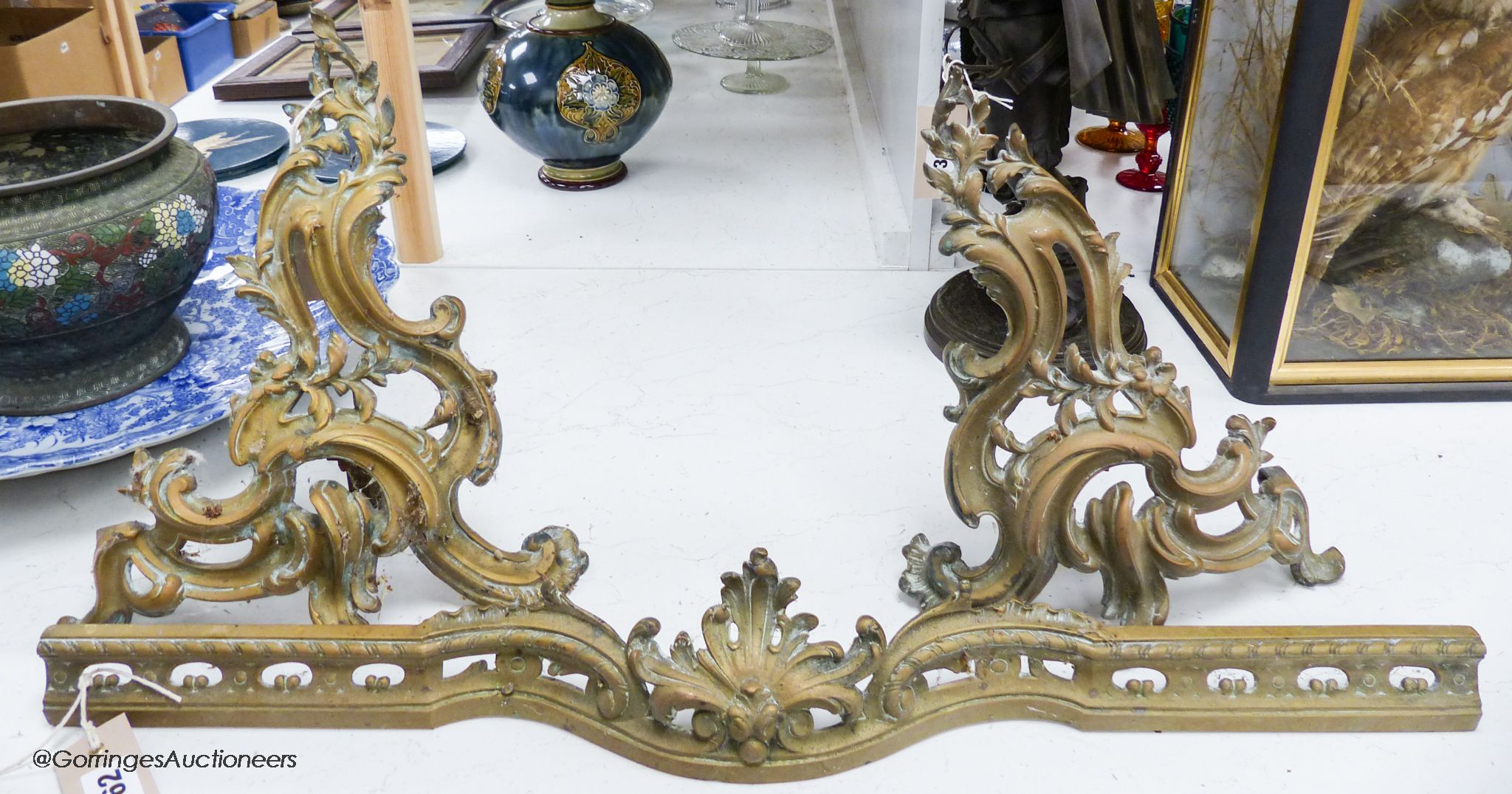 A pair of 19th century French rococo style ormolu andirons with linking fender